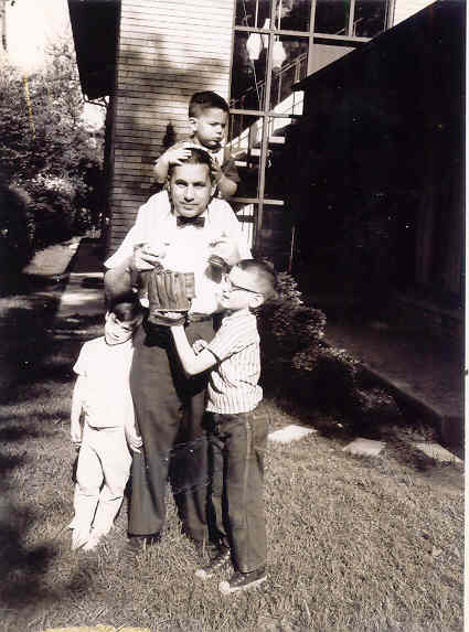 Karen, Dad, Larry, Steve on lawn, Larry on shoulders!