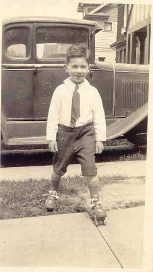 Young Richard Gach on skates in front of cool car...